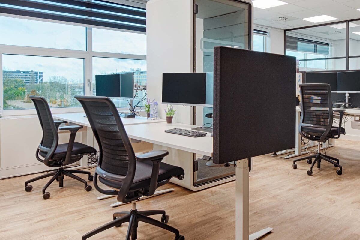Kantoor met bureaus, beeldschermen en bureaustoelen