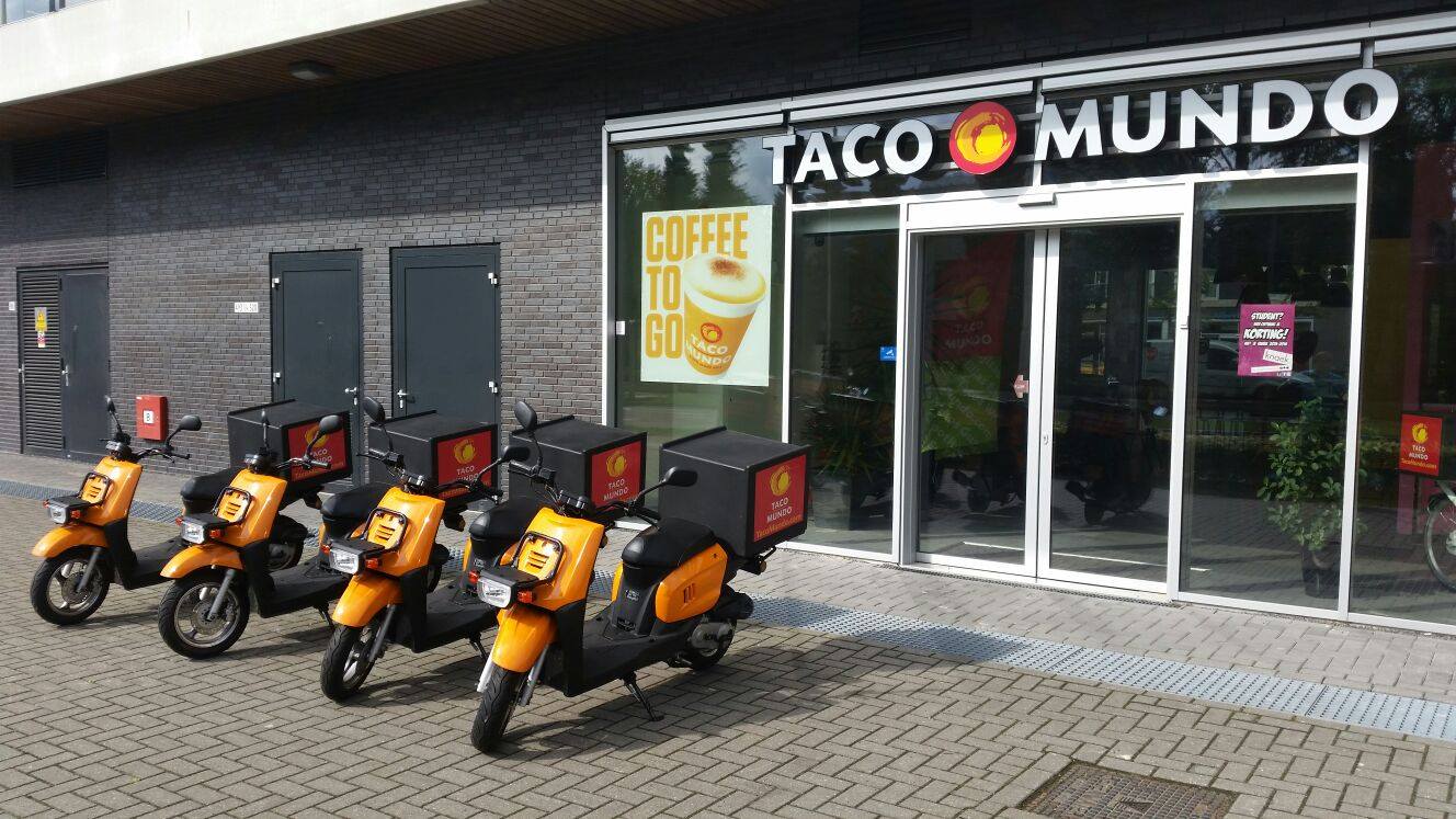 Oranje bezorgscooters voor een vestiging van Taco Mundo