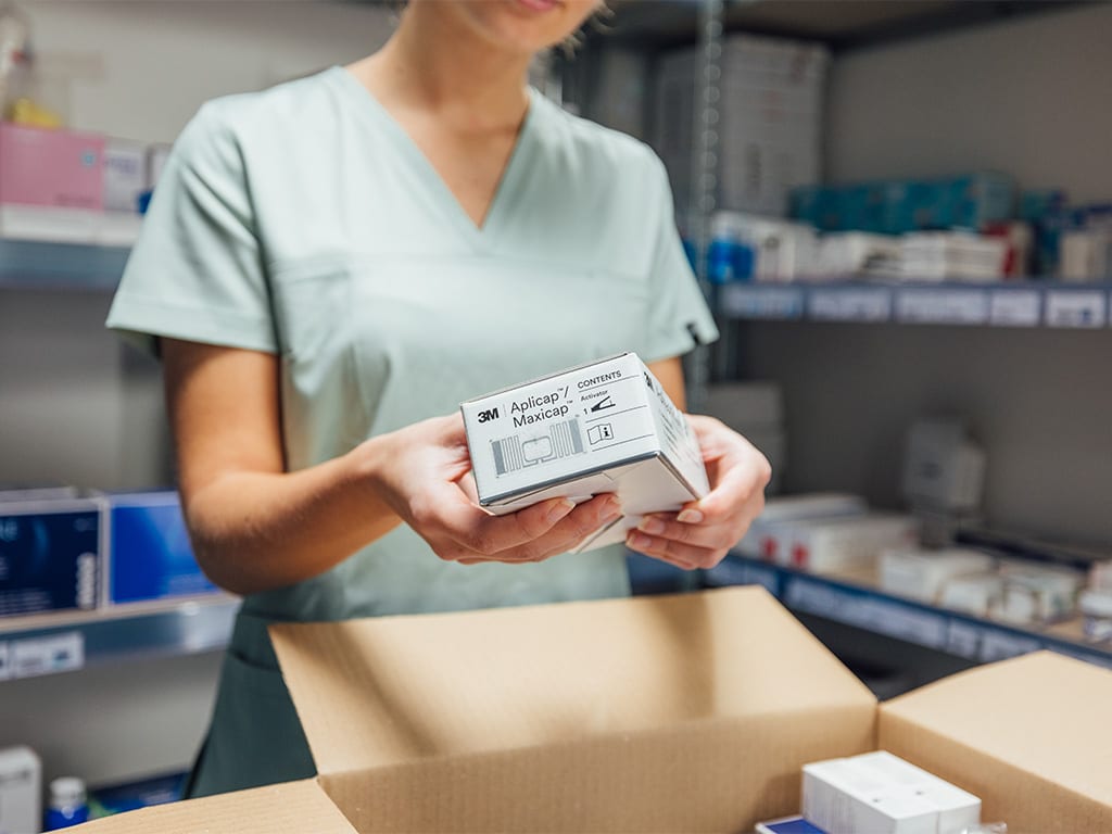Medewerker houdt een doos tandheelkundige producten met RFID-label vast