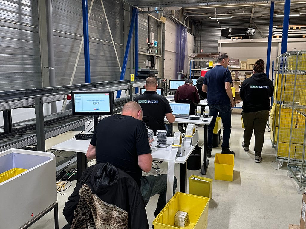 Medewerkers van Basiq Dental aan werkplekken voor het koppelen van RFID-labels