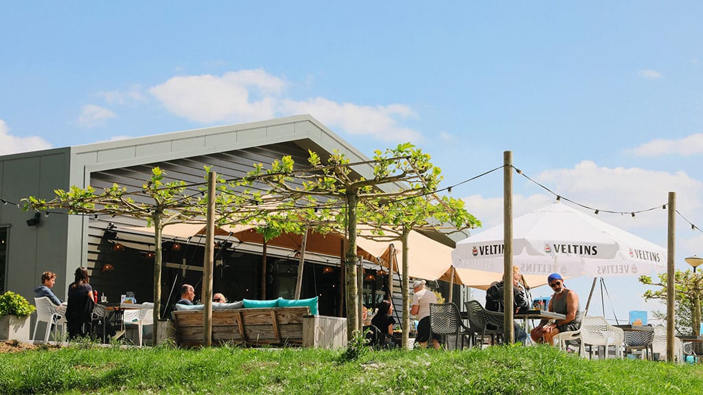 Terras van Riverside Outdoor met gasten in de zon