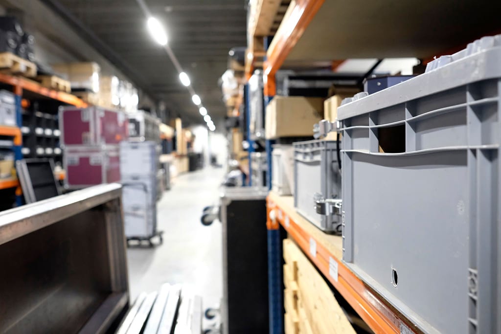 Magazijn met stellingen, kratten en flightcases